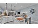 Open-concept kitchen with stainless steel appliances, quartz countertops, and views into the living area with fireplace at 3270 Green Heron Dr, Polk City, FL 33868