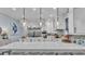 Bright kitchen features a large island, quartz countertops, stainless steel appliances, and modern pendant lighting at 3270 Green Heron Dr, Polk City, FL 33868