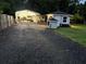 Backyard with shed and additional storage buildings accessible by a gravel driveway at 3646 Sherertz Road, Lakeland, FL 33810