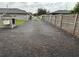 Gravel driveway with access to backyard and workshop area, surrounded by fencing at 3646 Sherertz Road, Lakeland, FL 33810