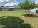 Large backyard featuring a lush lawn, mature shade tree, and newly updated home at 3646 Sherertz Road, Lakeland, FL 33810