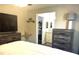 Cozy main bedroom featuring wood-look floors, TV and a view to a bathroom and walk-in closet at 3646 Sherertz Road, Lakeland, FL 33810