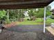 View from workshop to backyard, showing landscaping, seating, wood pile, and grass at 3646 Sherertz Road, Lakeland, FL 33810