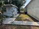 Backyard with concrete walkway leading to the house and a chain-link fence in the background at 3651 Rifle Range Rd, Winter Haven, FL 33880