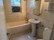 A full bathroom with tiled walls and floors, a toilet, tub, and sink at 3651 Rifle Range Rd, Winter Haven, FL 33880