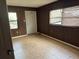 A bedroom featuring tiled floors and wood paneled walls at 3651 Rifle Range Rd, Winter Haven, FL 33880