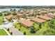 An aerial view captures a neighborhood of homes with tile roofs near a scenic lake and lush green landscaping at 3934 Aquilla Dr, Lakeland, FL 33810