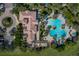 An aerial view shows a clubhouse with a clover-shaped pool, patio seating and verdant landscaping at 3934 Aquilla Dr, Lakeland, FL 33810