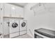 Functional laundry room with white washer and dryer units, storage cabinets, and sleek design at 3934 Aquilla Dr, Lakeland, FL 33810
