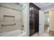 Bathroom featuring shower over tub with tiled wall and dark wood storage cabinet and door to hallway at 4006 Glen Garry W Rd, Lakeland, FL 33813