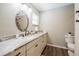 Bathroom vanity with decorative backsplash, and wood-look flooring, plus a toilet at 4006 Glen Garry W Rd, Lakeland, FL 33813