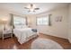 Bedroom featuring wood floors, ceiling fan, and two windows with side tables and bed at 4006 Glen Garry W Rd, Lakeland, FL 33813