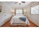 Bedroom featuring a bed, ceiling fan, wood floors, and two windows with side tables and lamps at 4006 Glen Garry W Rd, Lakeland, FL 33813