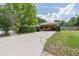 Single story home with a light colored exterior, long driveway, and a covered carport at 4006 Glen Garry W Rd, Lakeland, FL 33813