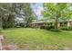 Charming brick home with a metal roof, mature trees, and green lawn in the front yard at 4006 Glen Garry W Rd, Lakeland, FL 33813