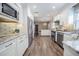 Open kitchen boasts wood flooring, stainless steel appliances, bright white cabinetry, and marble countertops at 4006 Glen Garry W Rd, Lakeland, FL 33813