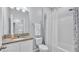 Well-lit bathroom featuring a granite countertop, framed mirror, and shower/tub combination with a patterned curtain at 4088 Prima Lago Cir, Lakeland, FL 33810