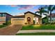 Charming home with a well-manicured lawn, brick driveway, beautiful landscaping, and neutral color palette at 4088 Prima Lago Cir, Lakeland, FL 33810