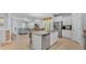 Expansive kitchen and living area with island seating, tile floors, and stainless steel appliances at 4088 Prima Lago Cir, Lakeland, FL 33810