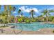 Large community pool featuring clear blue water, mature landscaping, and a building in the background at 4088 Prima Lago Cir, Lakeland, FL 33810