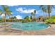 Spacious community pool with clear blue water, surrounded by palm trees and beautiful architecture at 4088 Prima Lago Cir, Lakeland, FL 33810