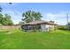 Lush backyard featuring a screened-in porch, wood fence, mature trees and well-maintained lawn at 4219 Sunny Land Dr, Lakeland, FL 33813