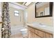 Well-lit bathroom featuring a bathtub with curtain, skylight, and tiled floor alongside a modern vanity with mirror at 4219 Sunny Land Dr, Lakeland, FL 33813