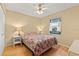 Sunlit bedroom boasts natural light from a window and is furnished with hardwood floors and a plush floral bedspread at 4219 Sunny Land Dr, Lakeland, FL 33813