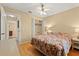 Comfortable bedroom showcasing a ceiling fan, closet and hardwood flooring, complemented by a cozy floral comforter at 4219 Sunny Land Dr, Lakeland, FL 33813