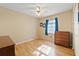 Cozy bedroom with hardwood floors, complemented by a ceiling fan, closet, and a sunny window with framed wall art at 4219 Sunny Land Dr, Lakeland, FL 33813