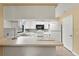 Open kitchen with breakfast bar, white cabinets and appliances, connecting to dining space at 4219 Sunny Land Dr, Lakeland, FL 33813