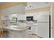 Bright kitchen with white cabinets, appliances and a breakfast bar, perfect for casual dining at 4219 Sunny Land Dr, Lakeland, FL 33813