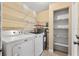 Functional laundry room with washer, dryer, and shelving for storage, providing convenience and organization at 4219 Sunny Land Dr, Lakeland, FL 33813