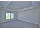 Bedroom with a window, carpeted floors, tray ceiling and neutral color palette at 4300 Juliana Lake Dr, Auburndale, FL 33823