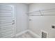 Functional laundry room with a wire shelf, utility connections, and easy access to the door at 4300 Juliana Lake Dr, Auburndale, FL 33823