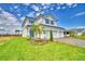 Attractive two-story home with a three-car garage, a neatly landscaped yard, and a bright blue entrance at 4449 Juliana Lake Dr, Auburndale, FL 33823