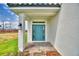Close-up of a home's front entrance showcasing a striking blue door, brick pavers, and manicured landscaping at 4449 Juliana Lake Dr, Auburndale, FL 33823
