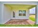 Covered brick patio with a door and window overlooking the grassy yard at 4449 Juliana Lake Dr, Auburndale, FL 33823