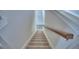 Carpeted stairway with a wooden handrail and neutral walls at 4449 Juliana Lake Dr, Auburndale, FL 33823