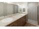 Modern bathroom featuring double sinks, granite countertops, and a tiled shower at 445 Silverbell Trl, St Cloud, FL 34771