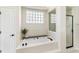 Bright bathroom featuring a soaking tub with jets, a glass block window and shower, and white tile at 4642 Highlands Place Dr, Lakeland, FL 33813