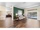 Bright living room with hardwood floors, view of pool, and decorative green accent wall at 4642 Highlands Place Dr, Lakeland, FL 33813
