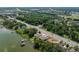 An aerial view of a lakefront property featuring a private dock, lush greenery, and multiple nearby roadways at 5026 N Socrum Loop Rd, Lakeland, FL 33809