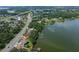 Aerial view showcasing the house near the water with a dock and lovely landscaping and surrounding trees at 5026 N Socrum Loop Rd, Lakeland, FL 33809