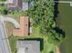 Overhead view highlighting a home's roof, driveway, and proximity to the lake, with lush greenery at 5026 N Socrum Loop Rd, Lakeland, FL 33809
