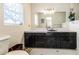 Bathroom featuring tiled walls, dark cabinets, and a sleek mirror, combining classic charm and functionality at 5026 N Socrum Loop Rd, Lakeland, FL 33809