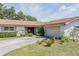 Home featuring a well-kept lawn, mature plantings, and attached two car garage at 5026 N Socrum Loop Rd, Lakeland, FL 33809