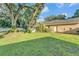 Spacious backyard with lush green lawn, mature landscaping, and a screened porch at 5108 Waterwood Dr, Bartow, FL 33830