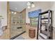 Updated bathroom features a glass enclosed shower, storage shelving, and decorative finishes at 5108 Waterwood Dr, Bartow, FL 33830