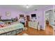 Inviting bedroom features hardwood floors, purple paint, and ceiling fan at 5108 Waterwood Dr, Bartow, FL 33830